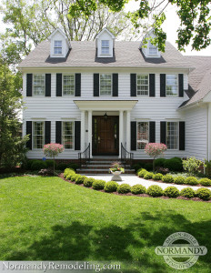 White Colonial style home with three dormers White colonial style home