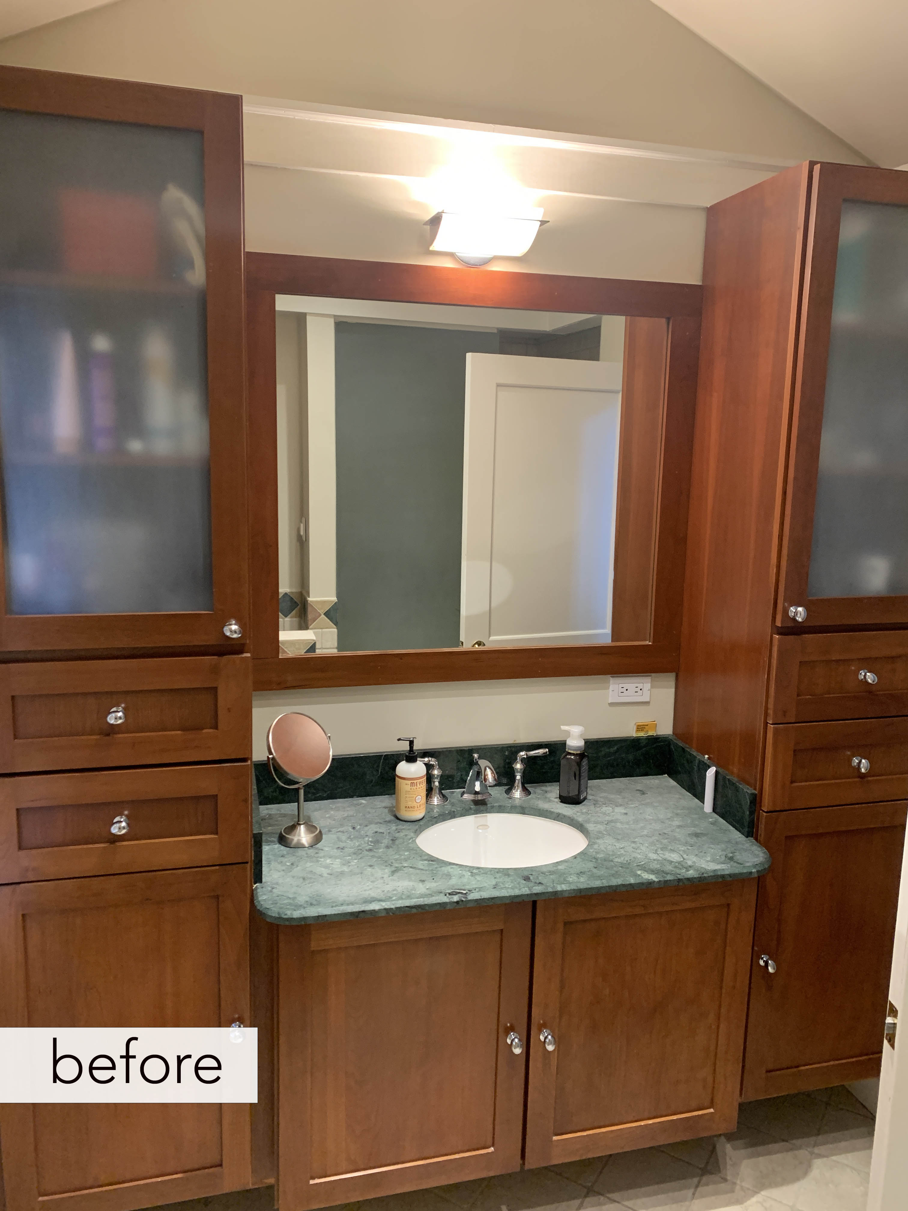 before bathroom with dark vanity flanked by tall storage